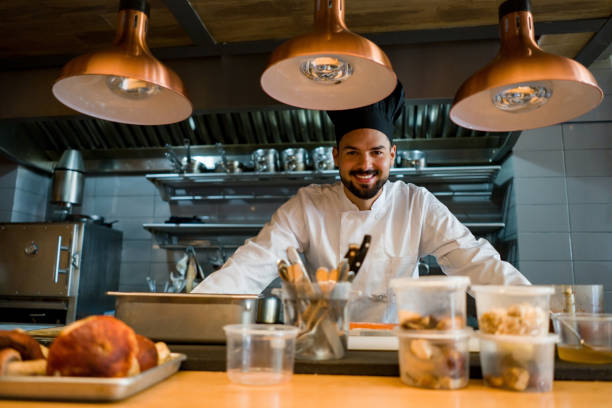 istock Happy chef working at a restaurant and smiling in the kitchen 1341912059