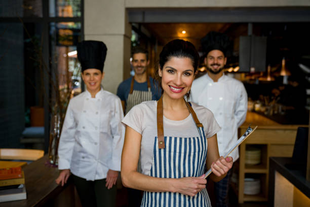 istock Happy waitress leading a group of workers at a restaurant 1341912087