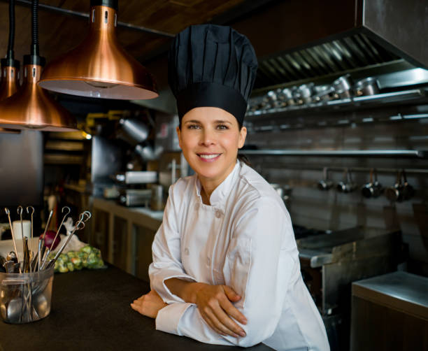 ritratto di uno chef di successo in un ristorante e sorridente - hat women chef occupation foto e immagini stock