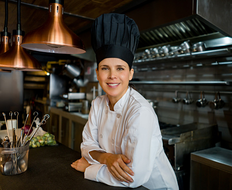 Portrait of a successful Latin American chef working at a restaurant and looking at the camera smiling