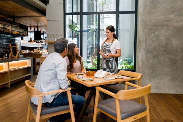 istock Happy waitress serving couple at a restaurant 1341912106