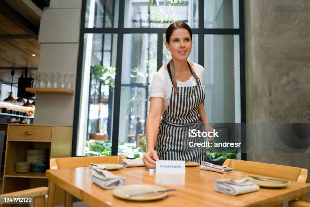 Waitress Putting A Reserved Sign On A Table At A Restaurant Stock Photo - Download Image Now