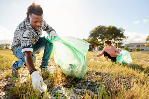 istock Two volunteers picking up garbage in a field during a community cleanup day 1341912293