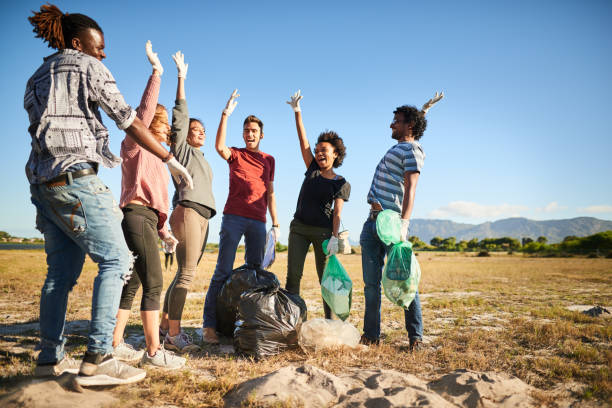 istock Diverse volunteers cheering together during a community cleanup day 1341913005