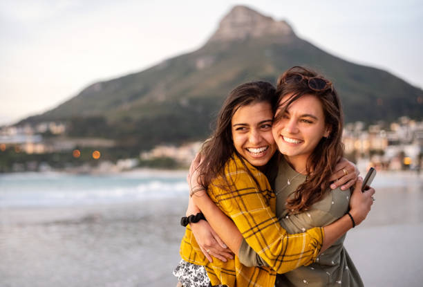istock Female friends on the beach at sunset 1341913239
