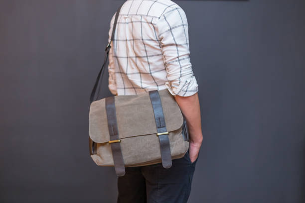 Man with a gray canvas messenger bag Man with a gray canvas messenger bag. Unisex bag for sale. men close up 20s asian ethnicity stock pictures, royalty-free photos & images