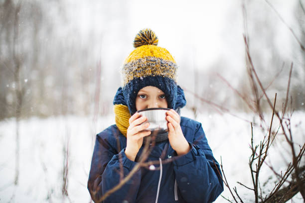 istock Little boy drinking hot tea outdoors in winter 1341913430