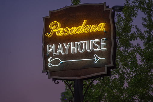 Pasadena, California, USA - September 4, 2021: image of the Pasadena Playhouse neon sign on Colorado Boulevard. This sign is considered a historic example of neon art.