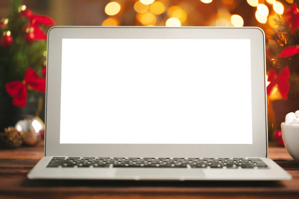 istock Wooden desk with computer with blank screen against blurred christmas lights background 1341918546