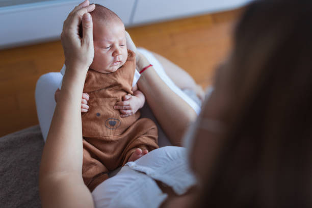 istock Tired newborn baby held by its mother 1341920911
