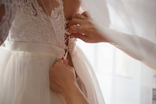 istock Dressing the bride in a lace white dress. 1341920955