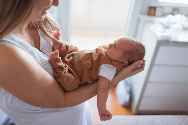 istock Joyful woman holding newborn baby 1341920982