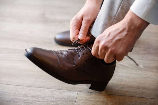 istock A man puts brown shoes on his feet. 1341921359