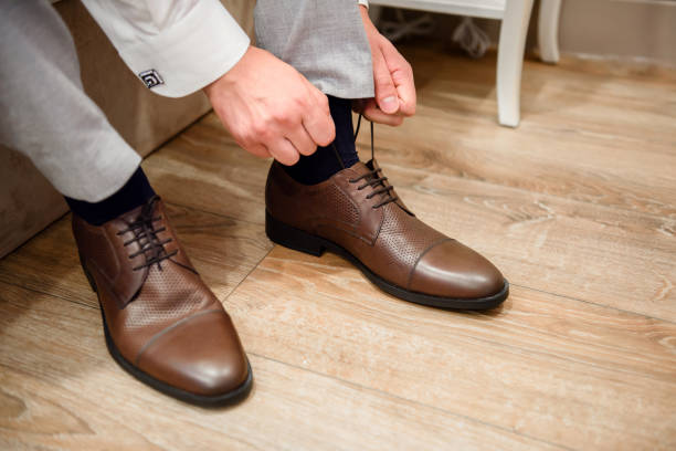 istock A man puts brown shoes on his feet. 1341921941