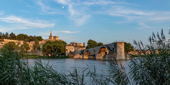 The Pont Saint-Benezet also known as the Pont d'Avignon, panoramic view on medieval bridge on the Rhone river in the town of Avignon, southern France in sunny summer day with blue sky and few clouds