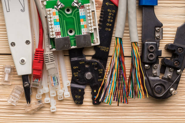 toma de red, par trenzado, acopladores, conector 8p8c (rj45), herramienta de engarce y otra herramienta para ensamblar redes de computadoras en una mesa de madera. - couplers fotografías e imágenes de stock