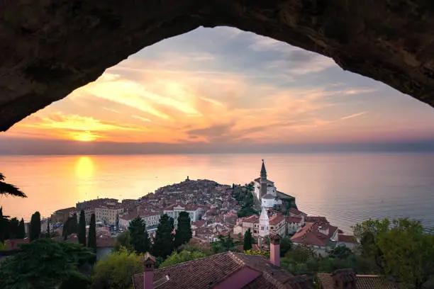 Photo of stunning sunset view from the piran city walls Piransko obzidje through wall window arch