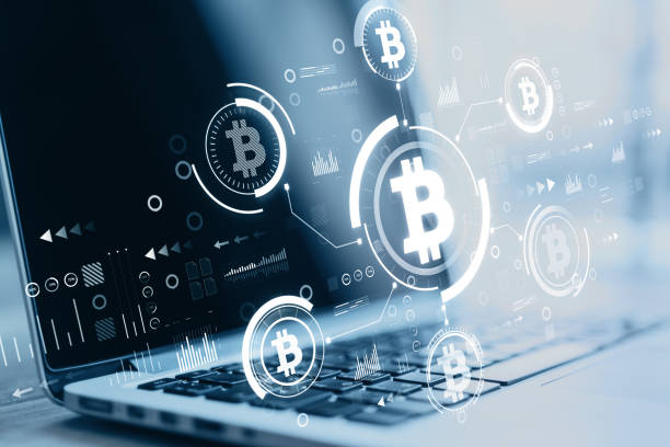 istock Close up of laptop at blurry desktop with creative glowing blue bitcoin interface on dark background. Finance, technology, cryptocurrency and exchange concept. Double exposure. 1341925813