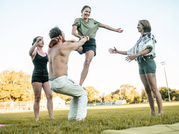 istock People practising Acro Yoga in the park 1341926247