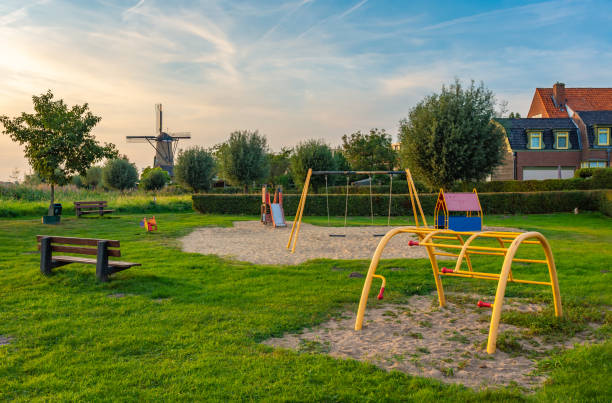 オランダの北ブラバントのテルヘイデン村にある遊び場と伝統的な風車を持つ子供に優しいオランダの地区 - オランダ ストックフォトと画像