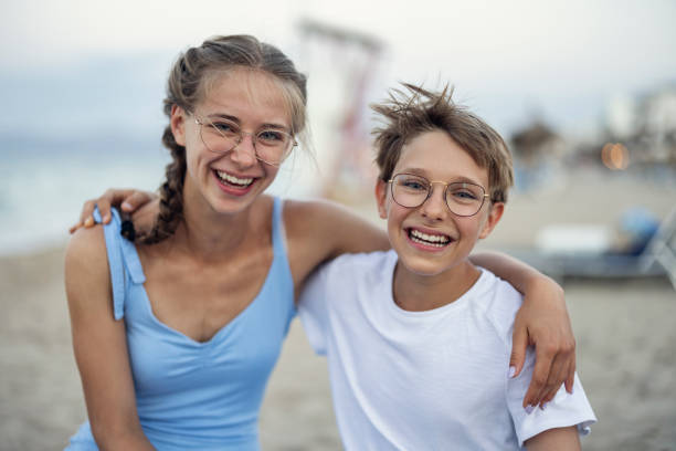 frère et sœur s’embrassant sur la plage - soeur photos et images de collection