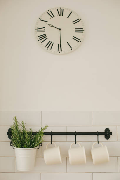 istock Kitchen interior with white wall and black rail with coffee mug and vase with fresh green rosemary 1341933383