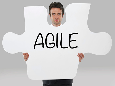 Businessman holding a missing piece of a puzzle with “Agile” text