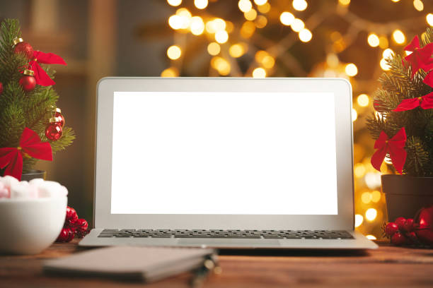 istock Wooden desk with computer with blank screen against blurred christmas lights background 1341937014