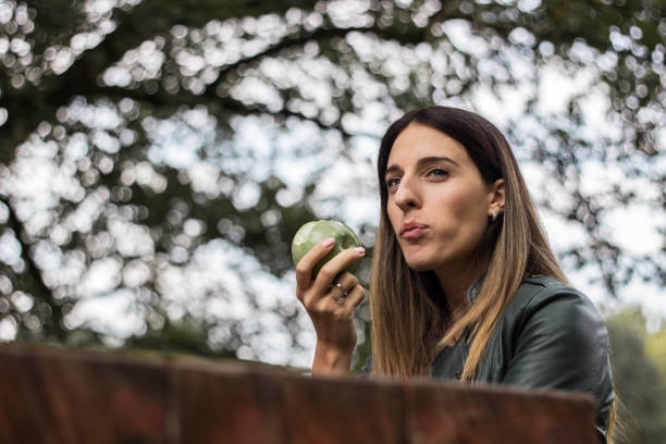 istock Cheerful young woman eating an apple 1341937040