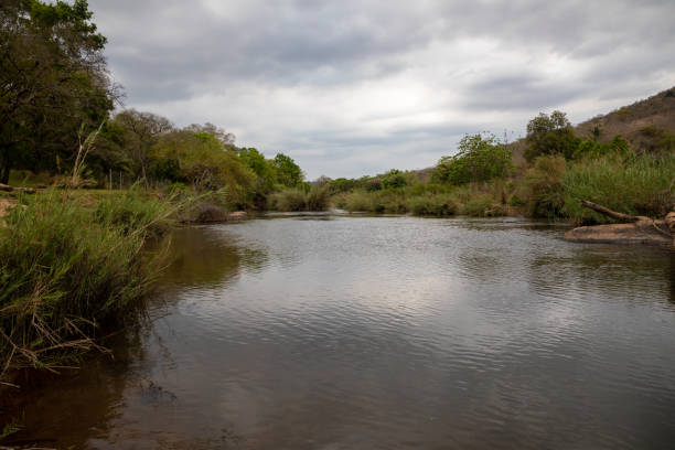 A tranquil river scene with the clouds reflecting in the water.