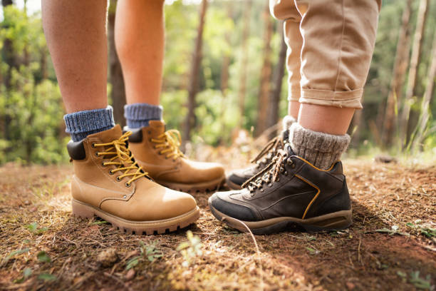 Young unrecognizable Caucasian hikers taking a break after a long hike in the woods. Traveling concept.