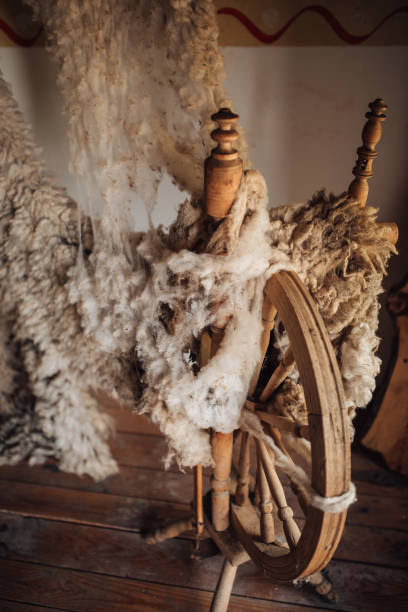 istock Antique wooden spinning wheel with sheep wool 1341938570