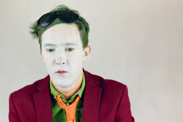 istock Actor with white makeup on face and green eyes and hair. 1341939999