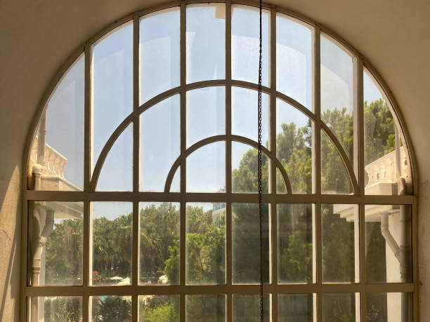 una grande finestra ad arco incorniciata da lesene bianche in stile classico - mullion windows foto e immagini stock