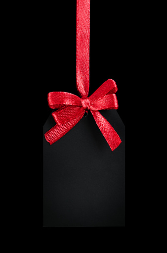 black tag with red bow on black isolated background