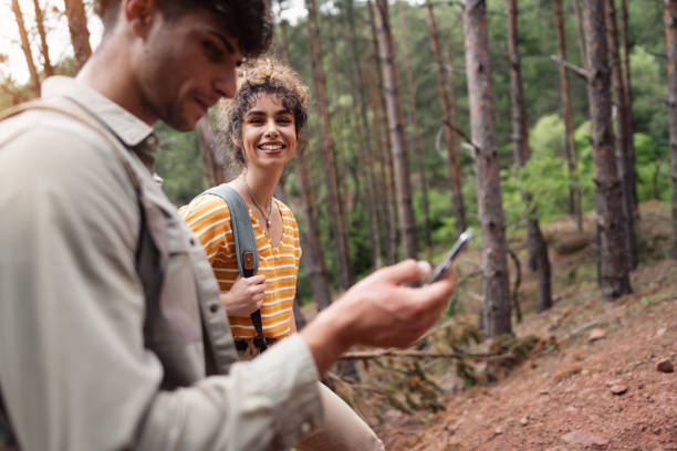 istock Young hikers using GPS map on their smart phone to navigate in woods 1341942518