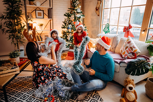 Happy family with two children is enjoying themselves at home as they prepare for Christmas and the New Year