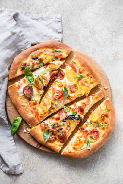 istock Pinsa with vegetables and cheese, concrete background. Traditional rome pizza. Top view. 1341946808
