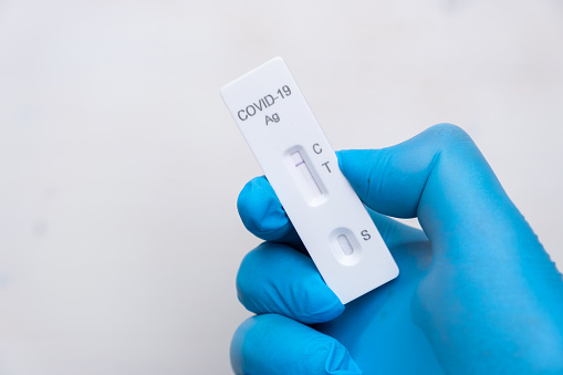 Negative Covid-19 antigenic test for quick detection of disease in doctors hand in the rubber gloves with copy space. Coronavirus test cassette from rapid strep kit