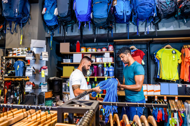 Small business owners Young male small business owners seen discussing about some hiking equipment in their outdoor sports store that they would like to place on the online shop. sports equipment stock pictures, royalty-free photos & images