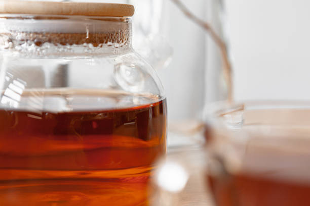 istock Glass tea pot with black tea on wooden table 1341950912