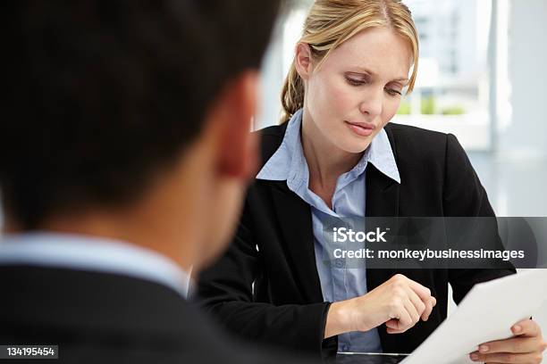 A Woman Interviewer Asking A Prospect About His Resume Stock Photo - Download Image Now
