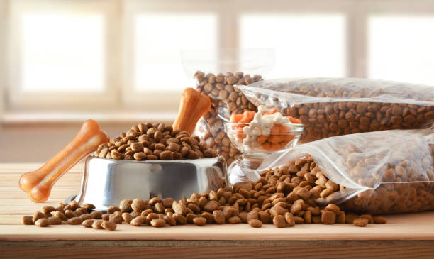 istock Dog croquettes in sacks and feeder on wooden table front 1341957265