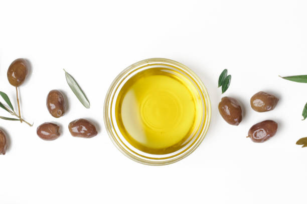 top view of extra virgin olive oil in bowl and olives isolated on white background. - olive oil pouring antioxidant liquid imagens e fotografias de stock