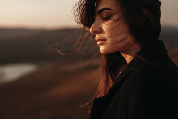 istock Thoughtful woman standing alone near lake 1341962034