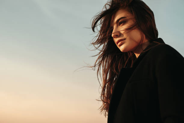 istock Thoughtful woman contemplating sunset in windy weather 1341962049