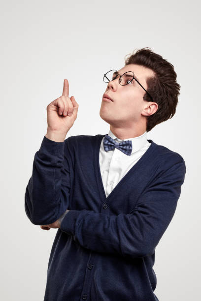 nerdy young man pointing up - humor asking nerd men imagens e fotografias de stock