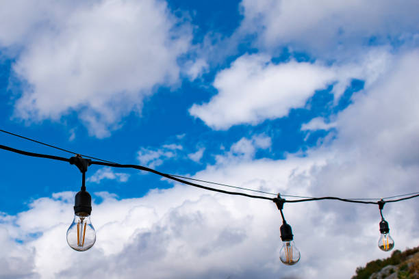 istock Series of light bulbs in a sky background 1341965371