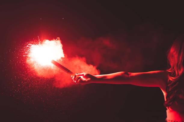 istock Man holding burning red sparkling Emergency Flaming Torch 1341966383