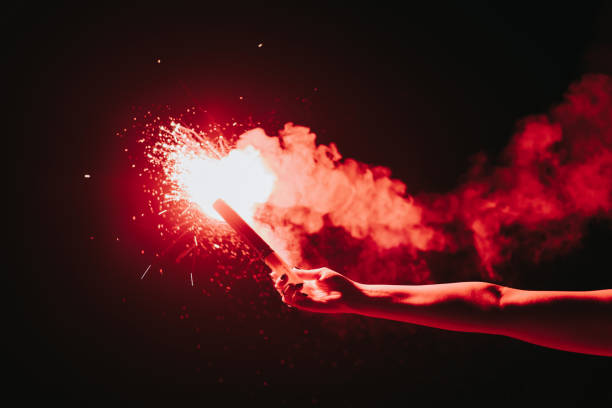 istock Hand holding burning red sparkling Emergency Flaming Torch 1341966419